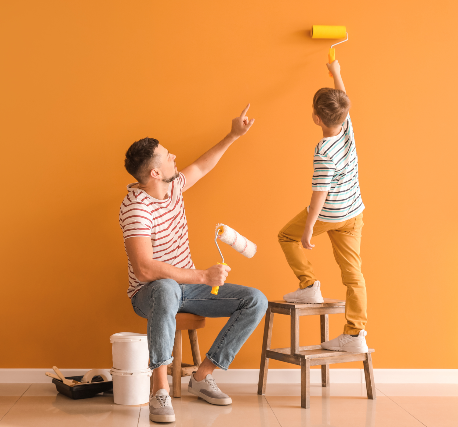 Dad And Son Are Painitng The Wall Orange